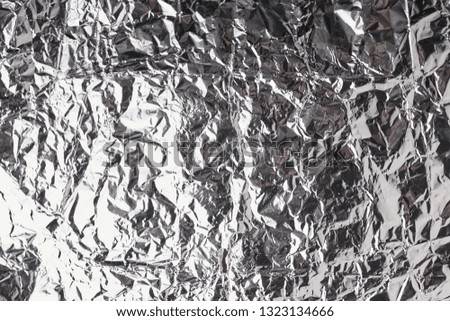 Silver crumpled foil shiny metal texture background wrapping paper for wallpaper decoration element. Grey platinum metallic