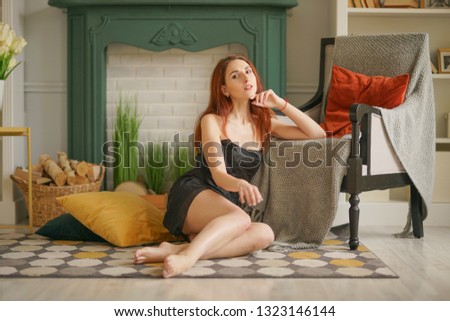 cute young girl sitting on the floor in front of a green fireplace and resting