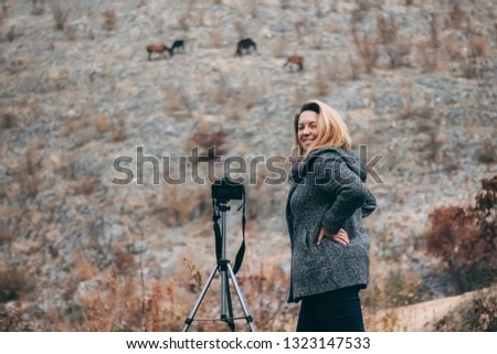Happy woman - photographer taking pictures of horses in the wild, success after many hours of waiting