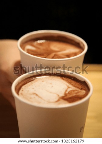Two cups of coffee with hand