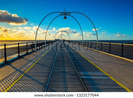 A long pier under a blue sky