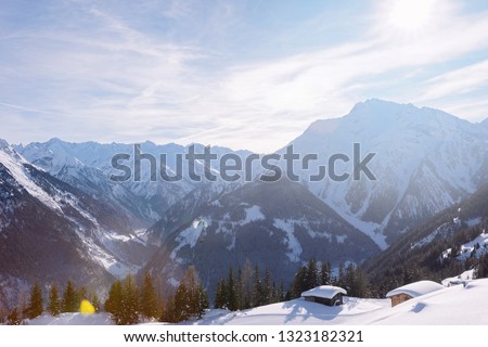 Landscape of Penken ski resort and snowy chalet in Zillertal in Tyrol. Mayrhofen in Austria in winter in Alps. Alpine mountains with snow. Blue sky and white slopes at Zell am Ziller.