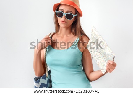 Mature woman wearing hat standing studio isolated on white wall carrying beach bag fan with map breathing hard feeling hot