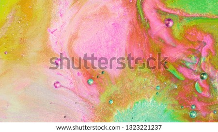Colorful sparkling paints mix in beautiful patterns. Oil ink of green, purple, yellow, red and other colors spread on the surface and mix one into another creating amazing textures and design.