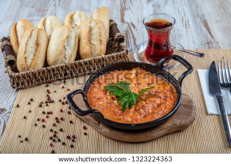 Menemen Turkish breakfast food egg, tomatoes and pepper in pan with concept background. Royalty-Free Stock Photo #1323224363