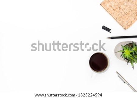 White office desk table with notebook, pen, cup of coffee and cactus pot. Top view with copy space, flat lay.
