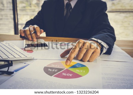 Businessman or accountant working on calculator to calculate business data concept. Accounting,investment advisor consulting situation on the financial report and planning a marketing plan at office.