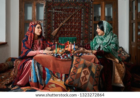 Novruz holiday celebration with Beautiful azeri women and novruz tray with traditional pastry shekerbura and pakhlava food. 