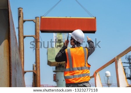 foreman, supervisor, worker, loading master in works at job site, control to the teamwork by walkie talkie radio for job done in the same direction, working at risk and high level of insurance Royalty-Free Stock Photo #1323277118