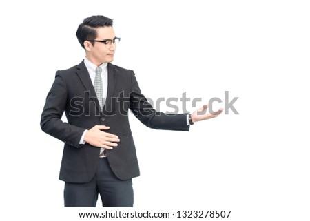 Happy young confident asian businessman with eyes glasses in formal black suit showing hand blank area for advertisement, sign, text, slogan .with copy space, isolated on pure white background