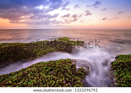 Slow shutter sunrise at Tip of Borneo, Malaysia with waves trails and green moss. Tanjung Simpang Mengayau also known as Tip of Borneo is the northernmost tip of Borneo Island.