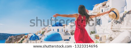 Europe travel vacation fun summer woman feeling free dancing with arms open in freedom at Oia, Santorini, Greece island. Carefree girl tourist banner panorama.
