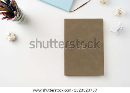 Design concept - Top view of man's hand hold high grade brown notebook isolated on white background for mockup series 1