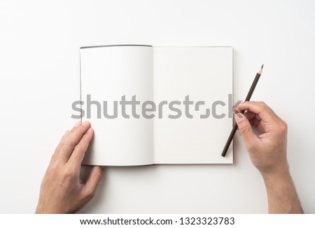 Design concept - Top view of man's two hand hold high grade brown notebook and pen isolated on white background for mockup