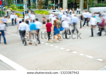 Rush hour, business people walking at crosswalk in downtown, motion blur, Singapore