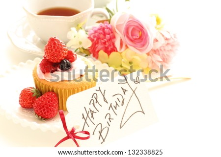 strawberry cup cake and birthday card with english tea on background