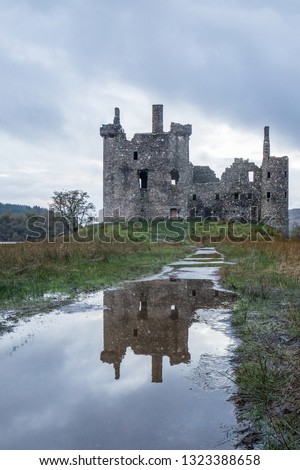 Old castle on the hill, colorful autumn around and overcast weather