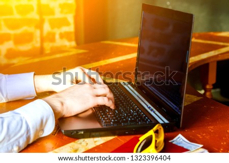 Male hands types something on the laptop keyboard
