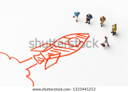 Miniature people on paper with with launching rocket sketch. Start up concept. 