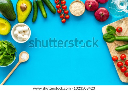 Fresh organic vegetables on blue background top view copy space. Kitchen desk for preparing salad