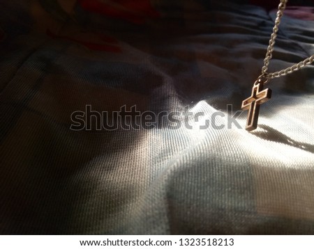 Close up view of golden Jesus christ cross necklace with shade light and shadow, God loving crucifix concept picture with selective focus