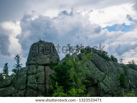 Cliffs, rocks, stones and a pine forest in Krasnoyarsk Pillars National Park. Summer time in Siberia.