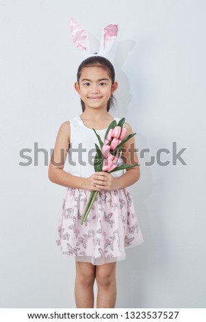 Cute little girl with easter bunny ears holding pink tulips wall bright gray background, Concept big sale spring  background