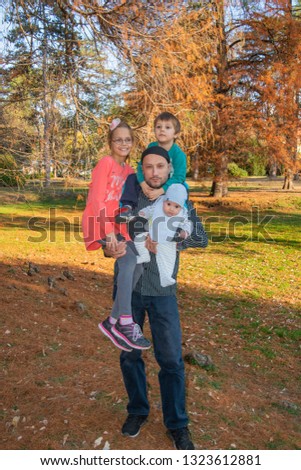Dad with three children in the arms in the park