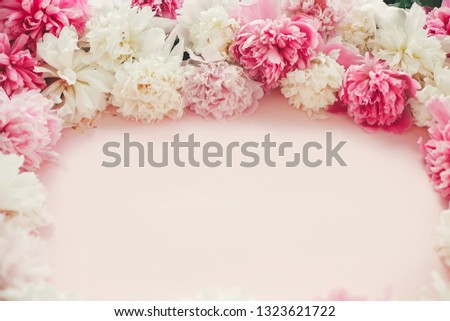 Stylish pink and white peonies frame on pink paper flat lay with space for text. Happy mother's day. International womens day. Greeting card mockup