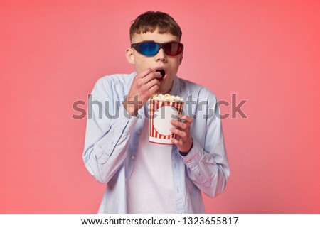  man in 3d glasses is watching a movie eating popcorn                              