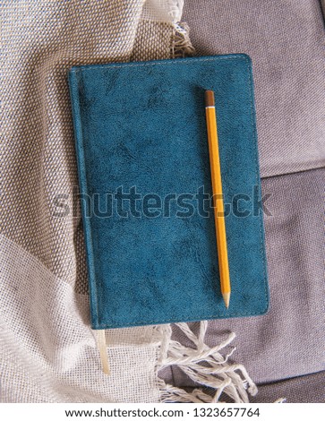 Top view with notebook and pencil on fabric background. Mock up for design 