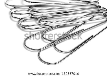 a pile of metallic paperclips on a white background