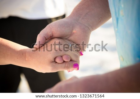Wedding couple holding hands with wifes wedding band visable