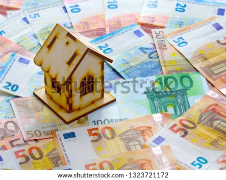 a bunch of european euro currency and a wooden house