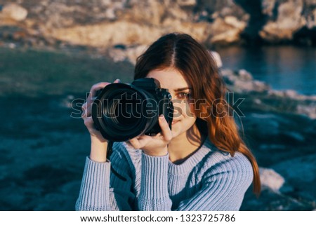 Pretty woman photographer in nature with a camera in her hands