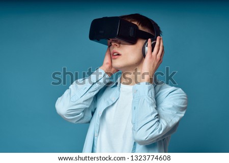   a man in a 3D glasses with headphones plays real virtuality                             