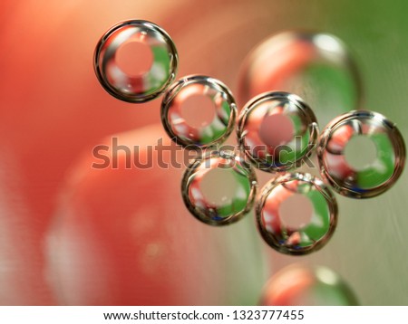 Abstract geometrical figure of glittering spheres. Close up shot. Blurred background. Selective soft focus. Abstract background. Scores of spheres glittering with green and pink lights. Macro shot