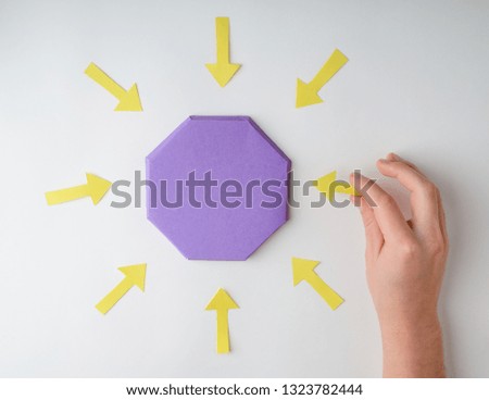 Hand putting arrows around octagon. Colorful paper diagram, graphic chart for presentation. Concentration concept.