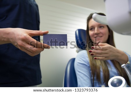 Dentist giving the patient his business card