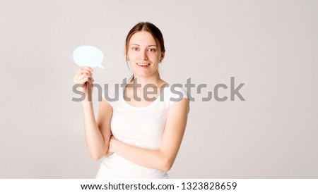 Portrait of an excited young business woman holding empty speech bubble isolated over white background