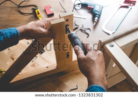 Man assembly wooden furniture,fixing or repairing house with screwdriver tool.modern living concepts ideas