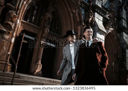Two fashion beautiful man models posing on city street. Wearing in classic and casual closes. Suit, coat, shirt, sweater, boots. Man model street test. Royalty-Free Stock Photo #1323836495