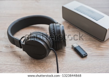 Black headphone,music player and thum drive put on wooden foor.