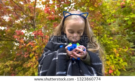 Overjoyed girl holding candies, making funny face, enjoying Halloween holiday