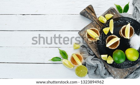 Tequila with salt and lime on a white wooden background. Top view. Free space for your text.