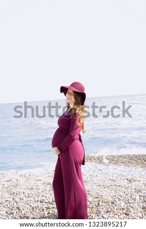 Red head pregnant woman with beach background 