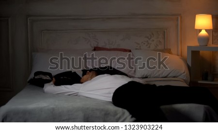 Happy businessman in suit lying on bed, successful investment, career promotion