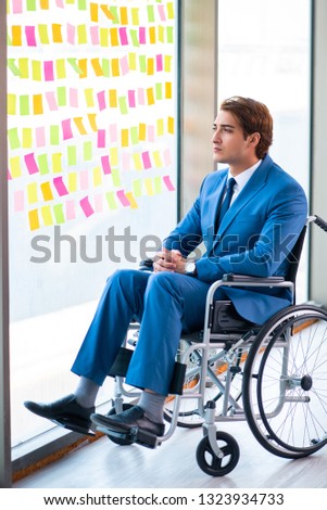 Young handsome man in wheelchair with many conflicting prioritie