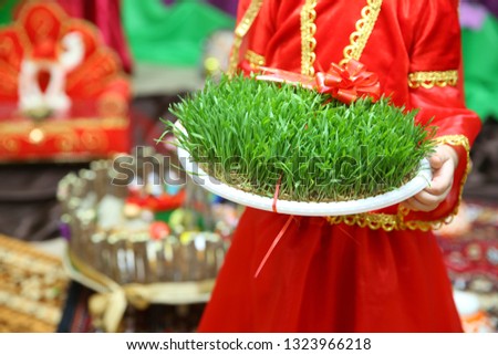 Female's hand in green Semeni . Navruz Nowruz holiday, the spring New Year holiday.
