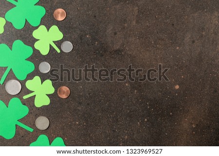 St.Patrick 's Day. Holiday. Frame of green leaves of clover and money on a brown background. top view. space for text